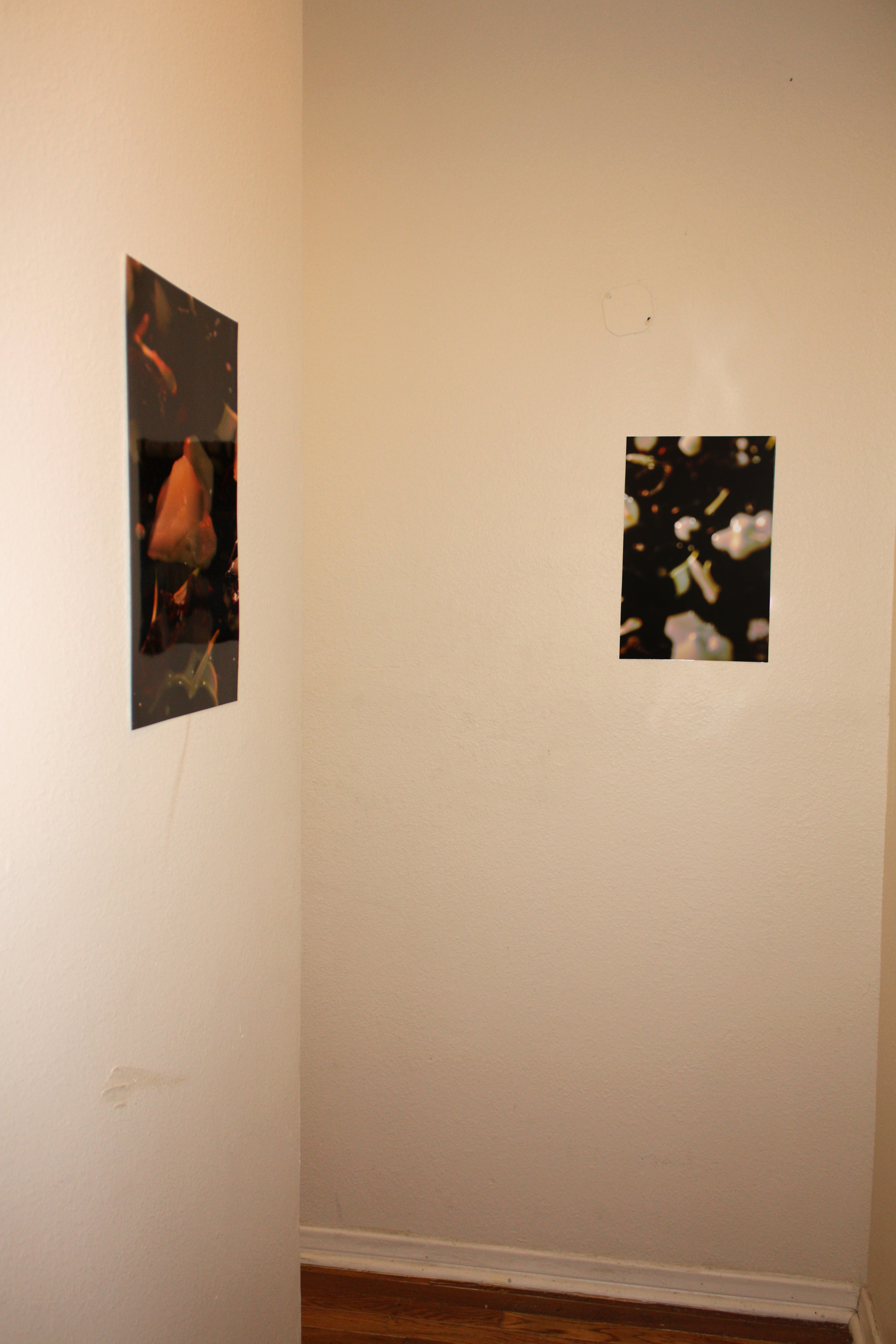 Two small glossy photo prints hung on white walls